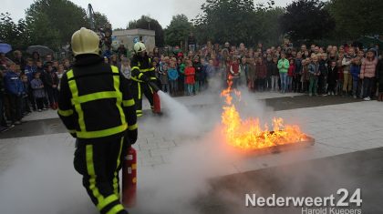 2013-10-11-Brandweer-dooft-vuur-Kinderboekenweek-basisschool-de-Klimop-1558 Nadat alle kinderen zich verzameld hadden rondom het vuur kwam de brandweer met loeiende sirene aangereden om het vuur te doven. Toen de klus geklaard was mochten alle kinderen zelf nog even blussen en natuurlijk het voertuig van buiten, maar vooral van binnen bekijken. Hoogte punt was natuurlijk de knop voor de sirene.