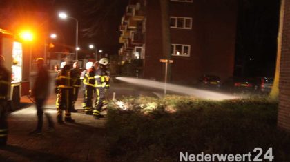Bosjes in brand bij flatgebouw