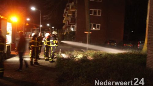 Bosjes in brand bij flatgebouw