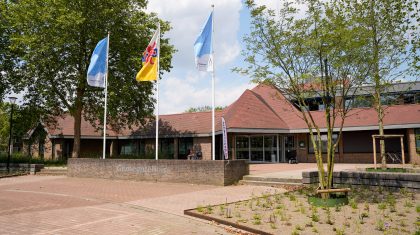 Het gemeentehuis aan het Raadhuisplein met de Nederweerter vlaggen in top.