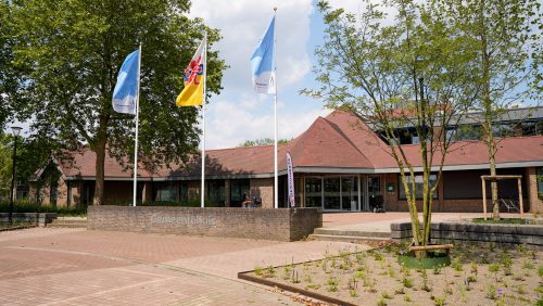 Het gemeentehuis aan het Raadhuisplein met de Nederweerter vlaggen in top.