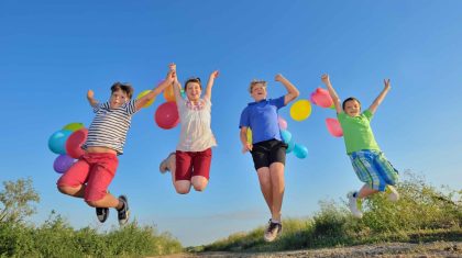 happy children jumping on field with balloons happy children jumping on field with balloons in summer time
