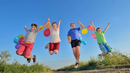 happy children jumping on field with balloons happy children jumping on field with balloons in summer time