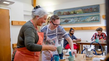 A man and woman prepare hot drinks in the local farm cafe.