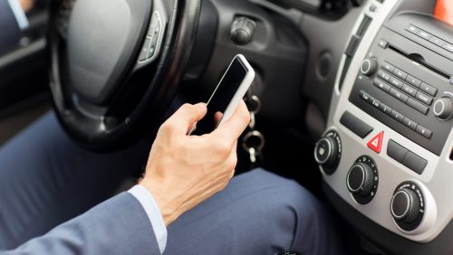 Mobiel-in-hand-in-auto transport, business trip, technology and people concept - close up of young man hand with smartphone driving car
