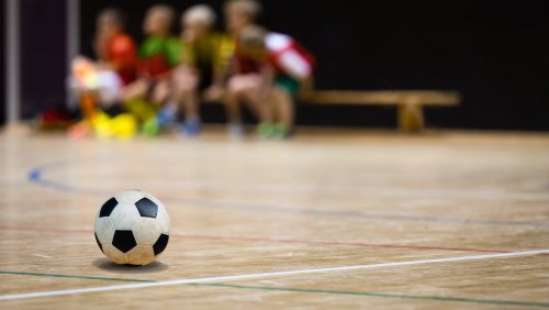 Football Futsal Ball and Youth Team. Indoor Soccer Sports Hall. Children Indoor Soccer Team. Sport Futsal background. Indoor Soccer Winter League for Kids